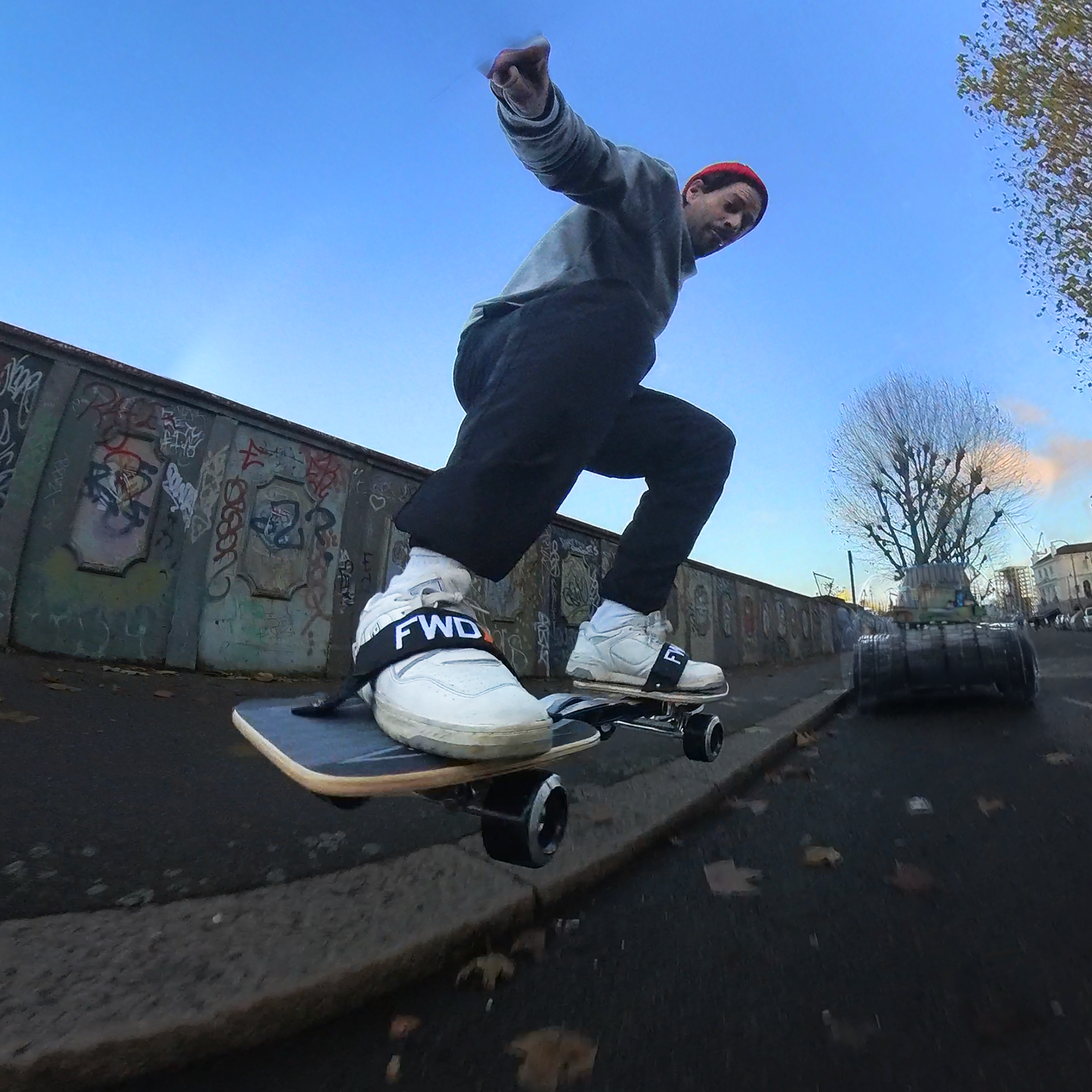 Jumping off a curb in London on a Snakeboard