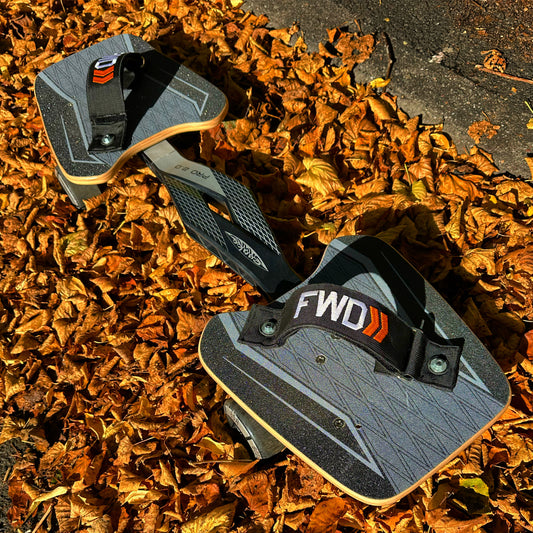 The Snakeboard Pro with Straps in a bed of leaves